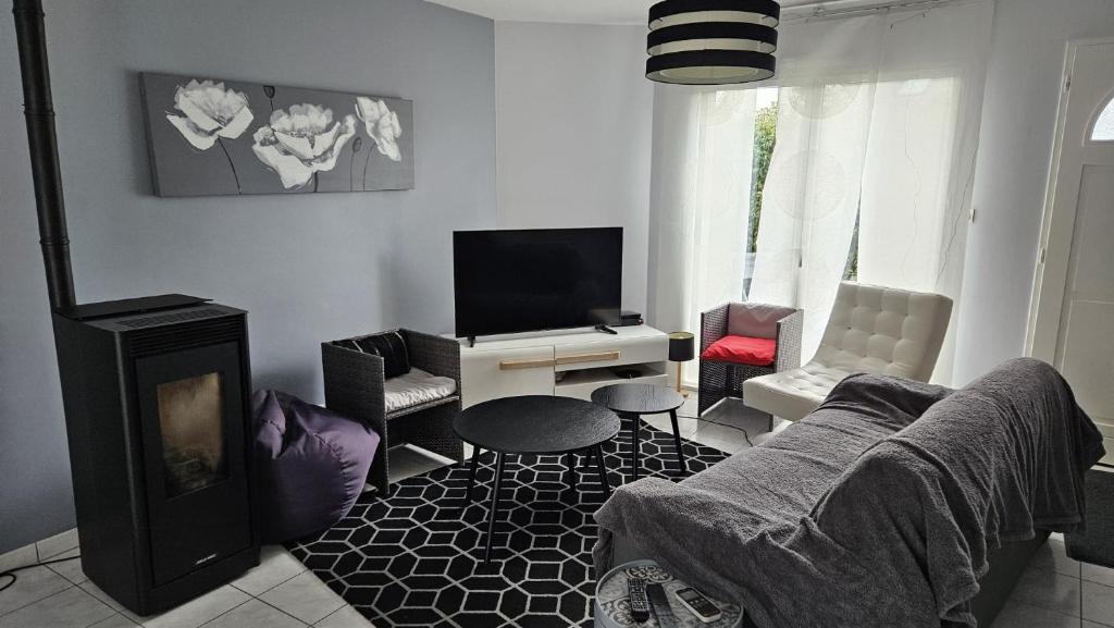 un salon avec un canapé et une cheminée dans l'établissement Maison proche de Rennes, 3-4 chambres, jardin, à Laillé