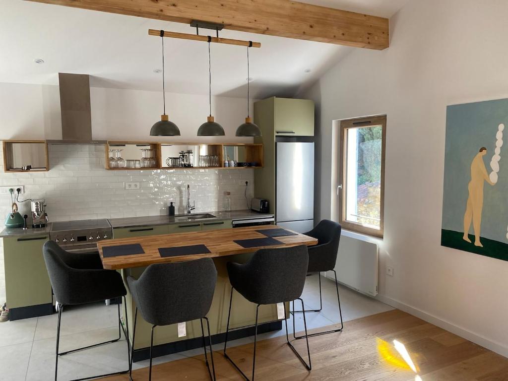 a kitchen with a table and some black chairs at Gîte lumineux avec jardin, vue sur Peyrepertuse in Rouffiac-des-Corbières