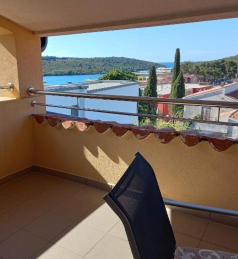 a balcony with a chair and a view of the water at Regina 1 in Banjole