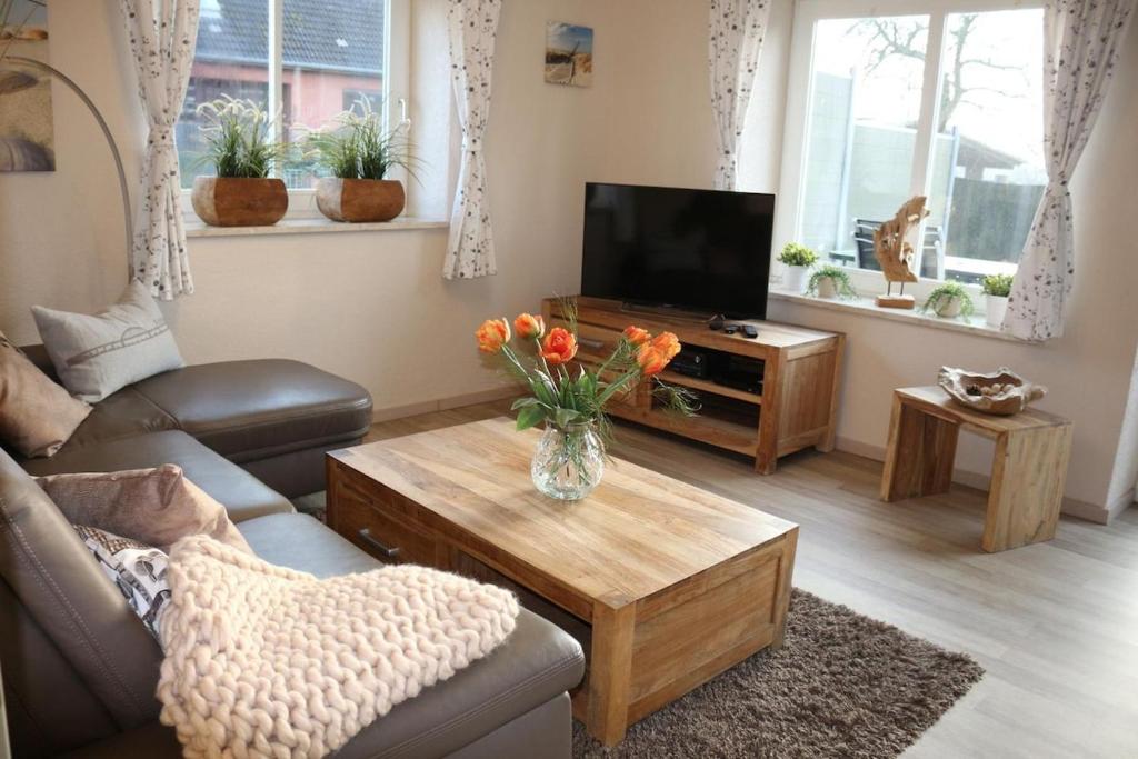 ein Wohnzimmer mit einer Vase aus Blumen auf einem Couchtisch in der Unterkunft Inselidylle Villa Saltkrokan in Fehmarn