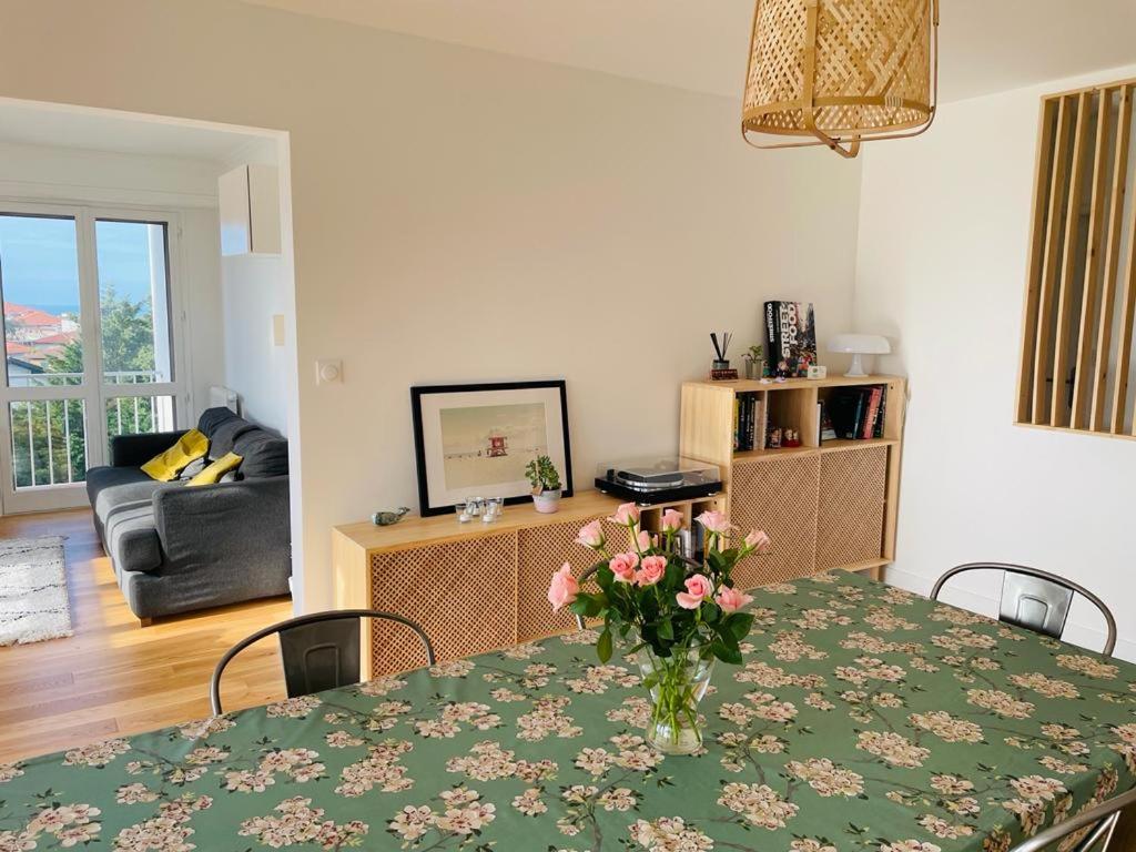 un salon avec une table avec un vase de fleurs dessus dans l'établissement Appartement 3 chambres, très lumineux, plages et centre ville à pied, à Biarritz