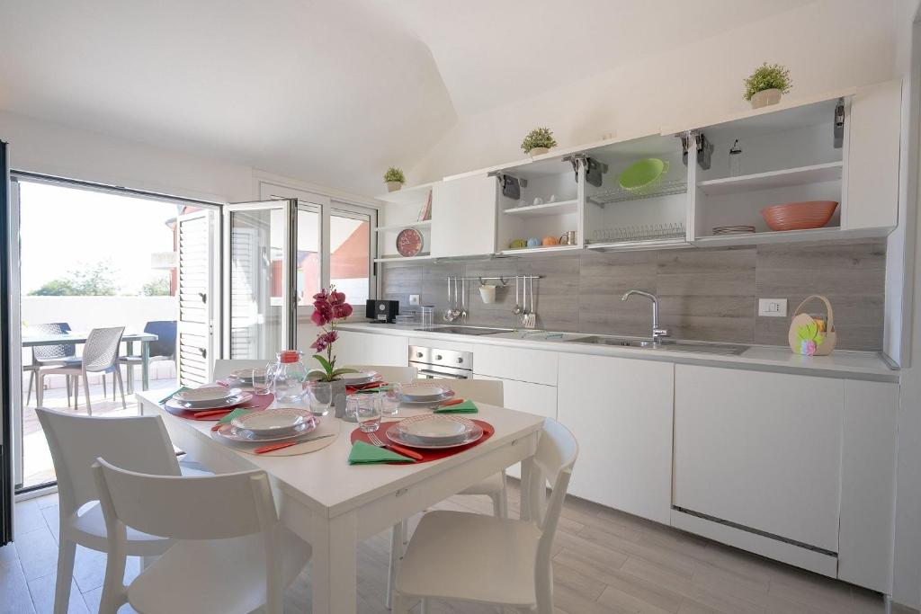 una cucina con tavolo e sedie bianchi e un tavolo di Il Topazio a Vasto