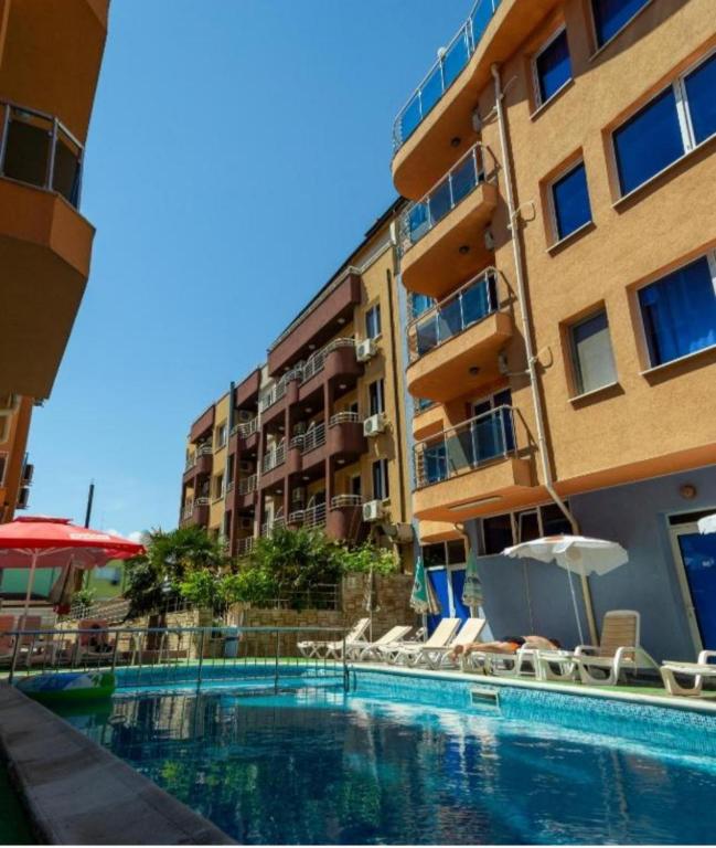 a swimming pool in front of a building at Лукс Апартамент Морска Перла in Primorsko