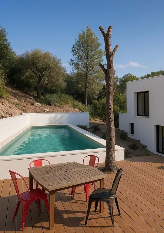 - une table et des chaises en bois à côté de la piscine dans l'établissement Provençal and Modern Villa ideal for families, à Le Tignet