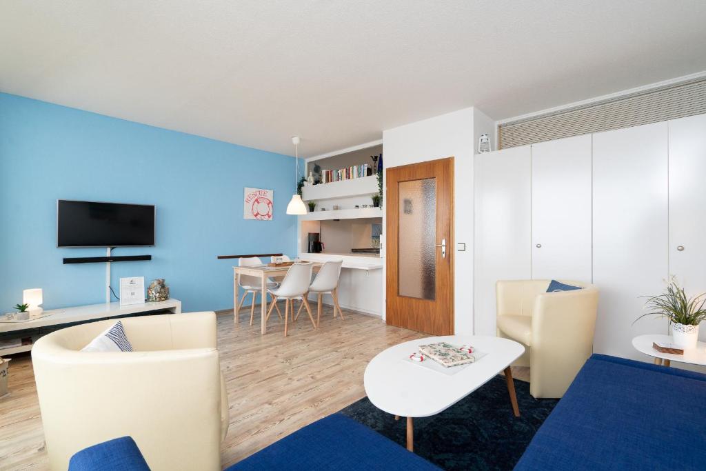 un soggiorno con pareti blu e tavolo e sedie di Ferienpark Sierksdorf App 746 - Strandlage a Sierksdorf