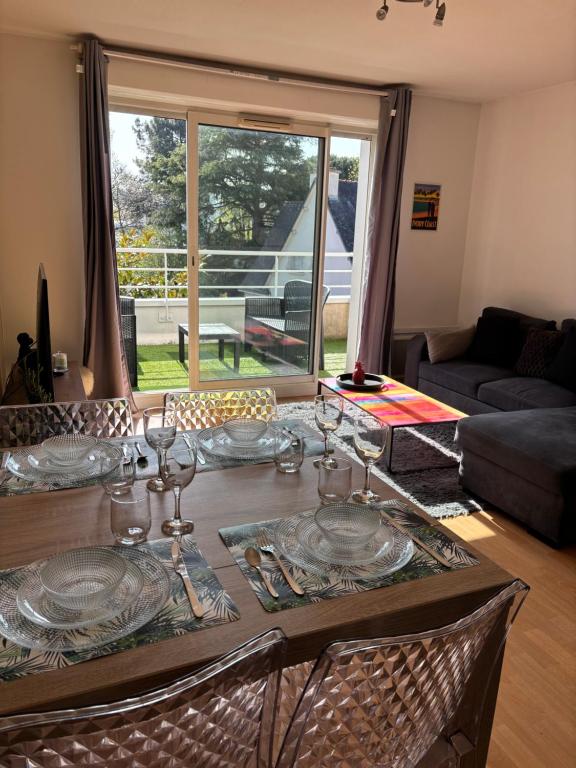 une table de salle à manger avec des assiettes et des verres dessus dans l'établissement Appartement deux chambres paisible, à Vannes