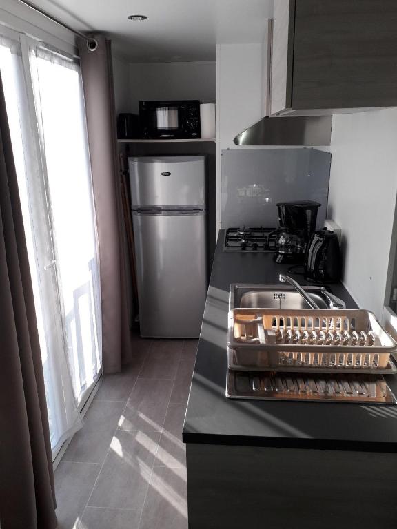 - une cuisine équipée d'une cuisinière four supérieur dans l'établissement Mobil home entre mer et forêt, à Camiers