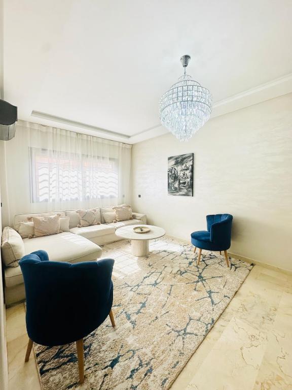 a living room with a couch and chairs and a chandelier at Charmant Appartement 2 Room Wifi Marrakech in Marrakesh
