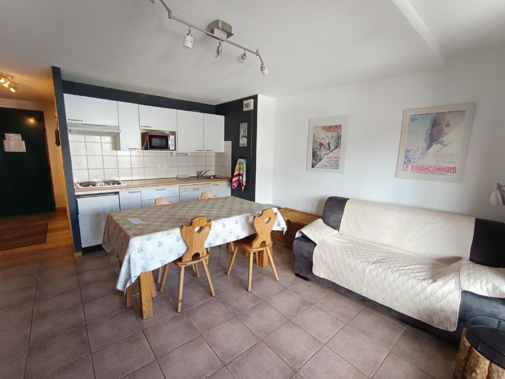 un salon avec une table et un canapé dans l'établissement Appartement avec balcon plein sud, parking et animaux admis - FR-1-445-165, à Montgenèvre