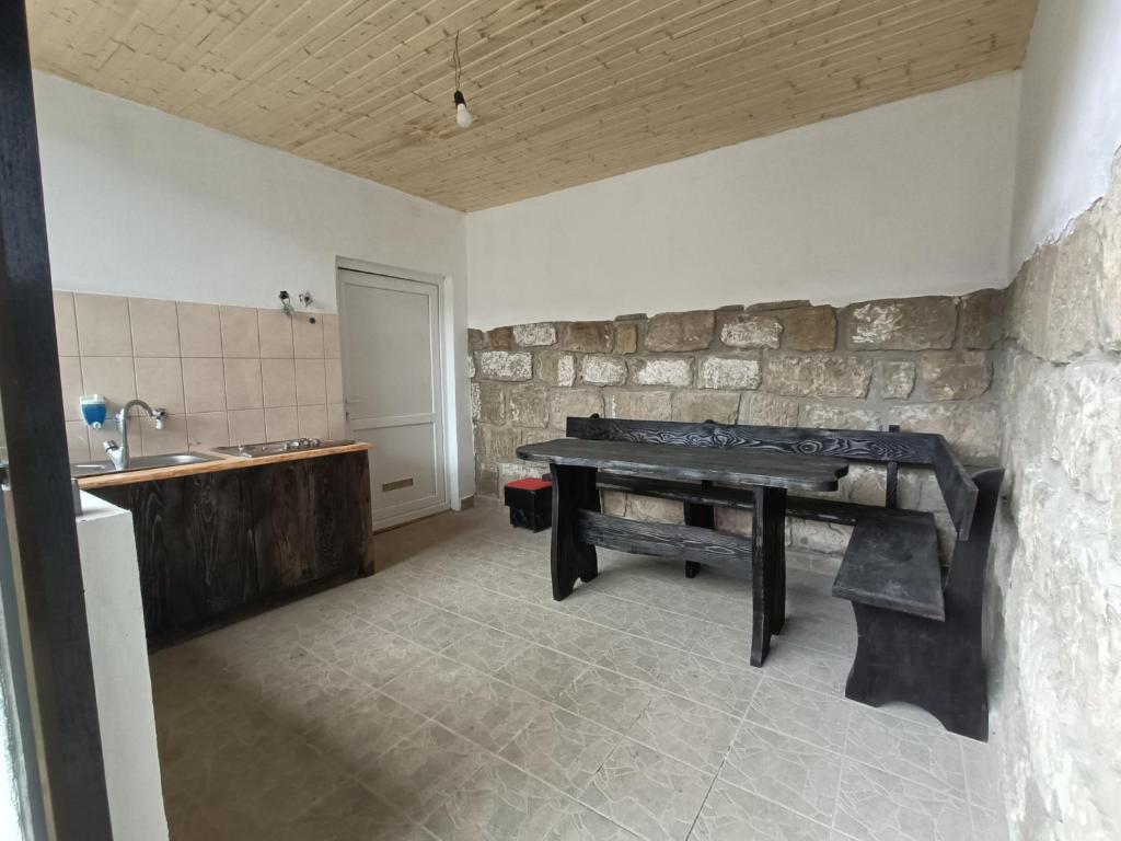 una cucina con tavolo e lavandino in una stanza di Casa Piatra Corbului a Gura Teghii