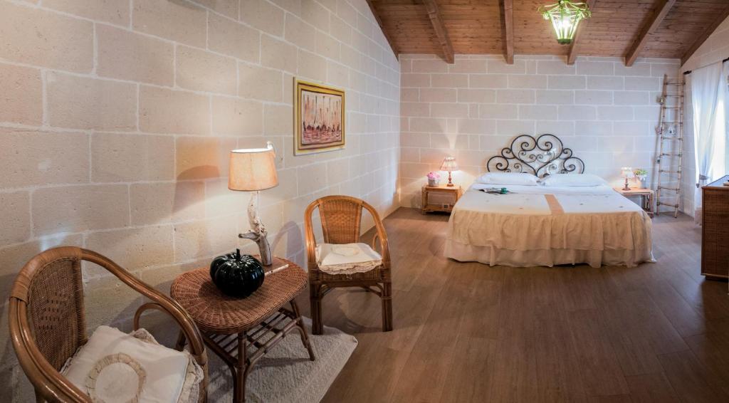 1 dormitorio con 1 cama y sillas en una habitación en Alba Bed & Breakfast, en Melendugno