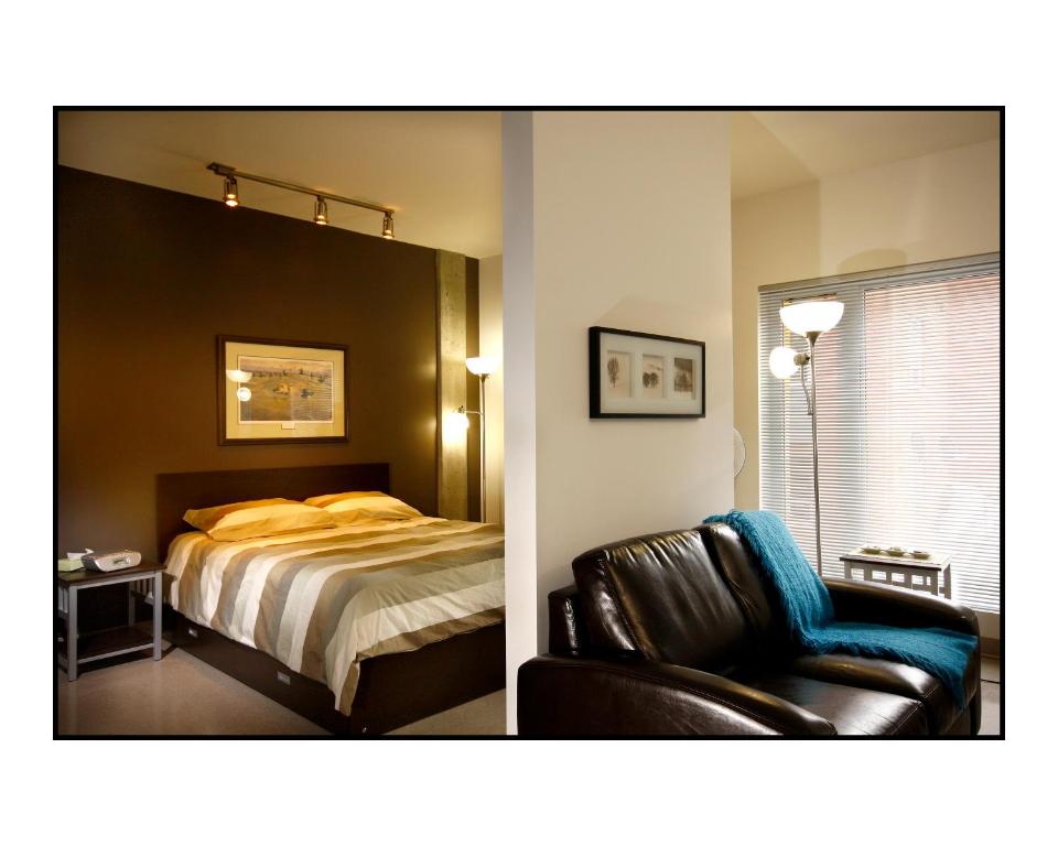 1 dormitorio con 1 cama y silla de cuero en Résidences Université du Québec, en Quebec