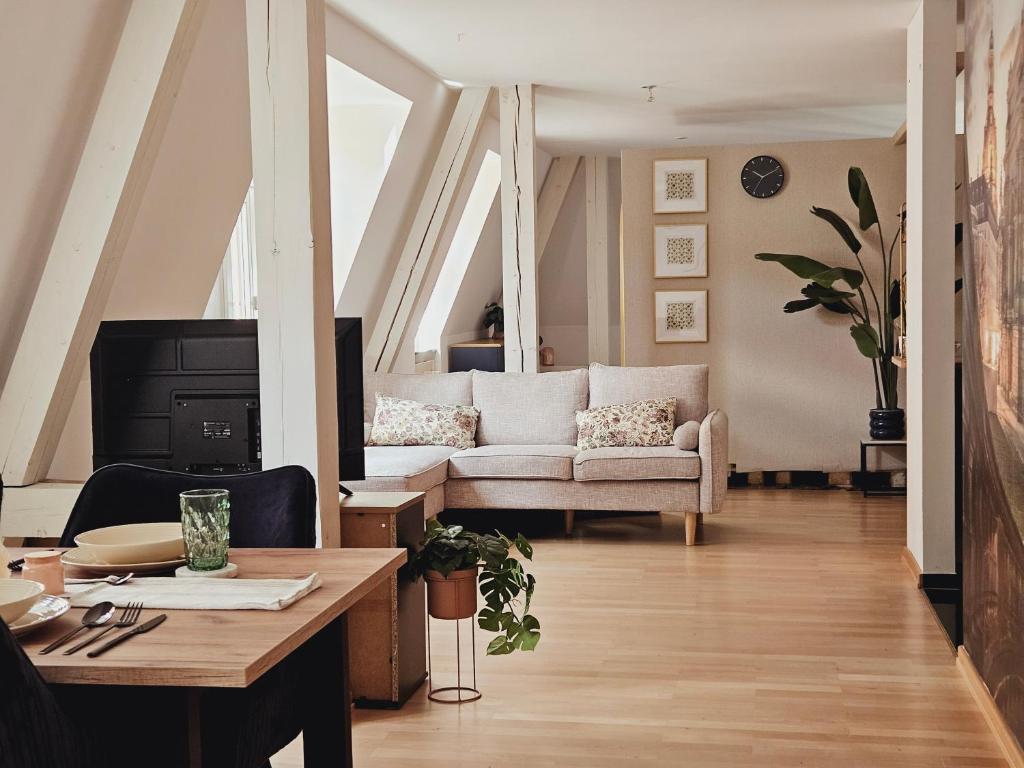 un soggiorno con un divano e un tavolo di Elegantes Loft mit 2 Etagen im Königsviertel a Dresda