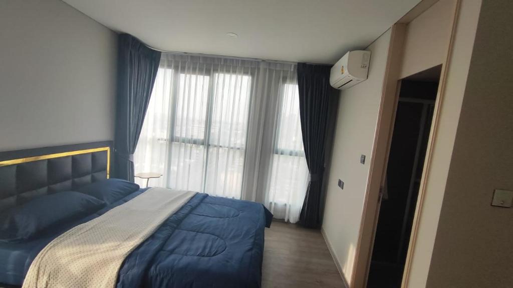 a bedroom with a blue bed and a window at Lumpini park chatuchak in Bangkok