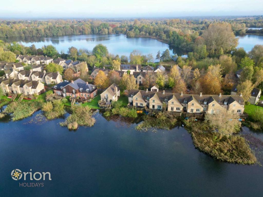 an aerial view of a house on an island in the water at Mill Village 67, Driftwood Lake House - P in Somerford Keynes