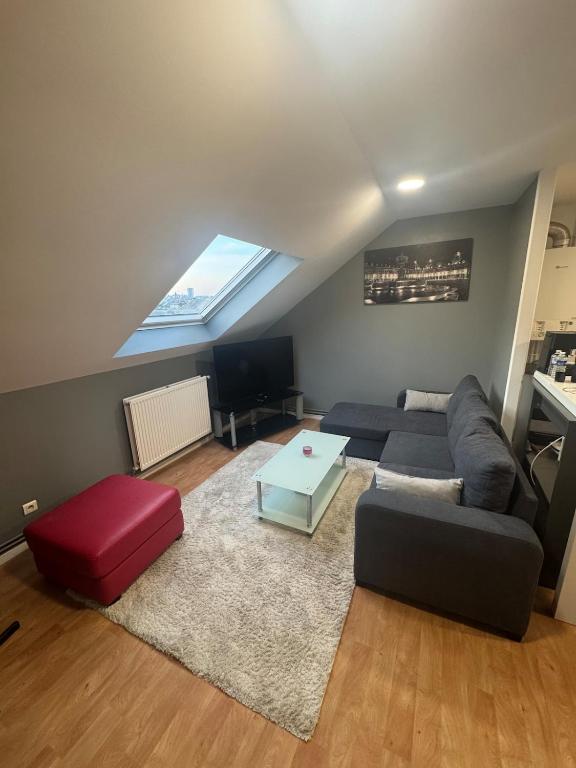 un salon avec un canapé et une table dans l'établissement Appartement, à Charleville-Mézières