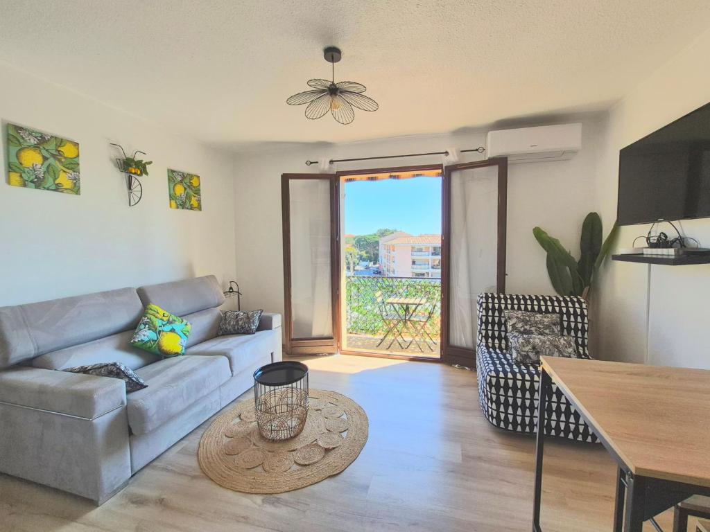 un salon avec un canapé et une table dans l'établissement Studio Limonista - cœur Saint Aygulf, à Saint-Aygulf