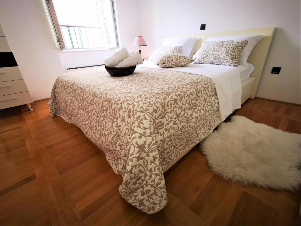 a bedroom with a bed with a white bedspread at Iron Gates Apartments in Split