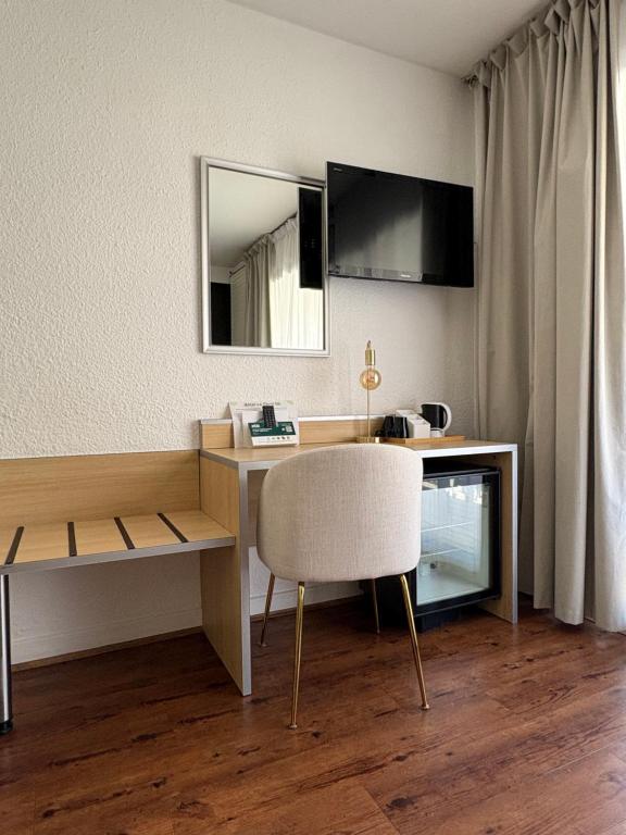 TV a/nebo společenská místnost v ubytování Cit'hôtel Le Chris'tel hôtel et restaurant