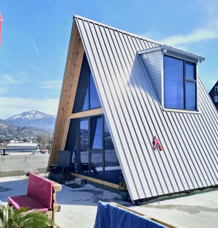 a small house with a large window on a roof at Redi house in Batumi