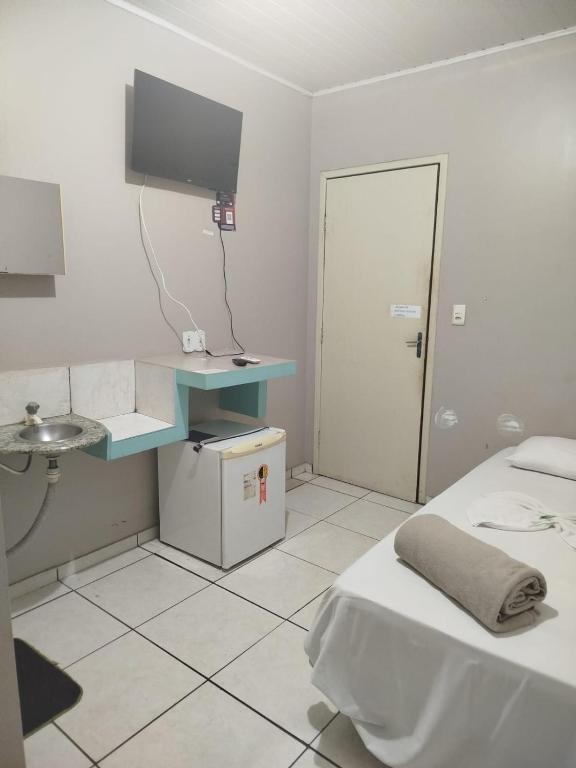 a room with a bed and a sink and a tv at Hotel Porto Amazônia in Porto Velho