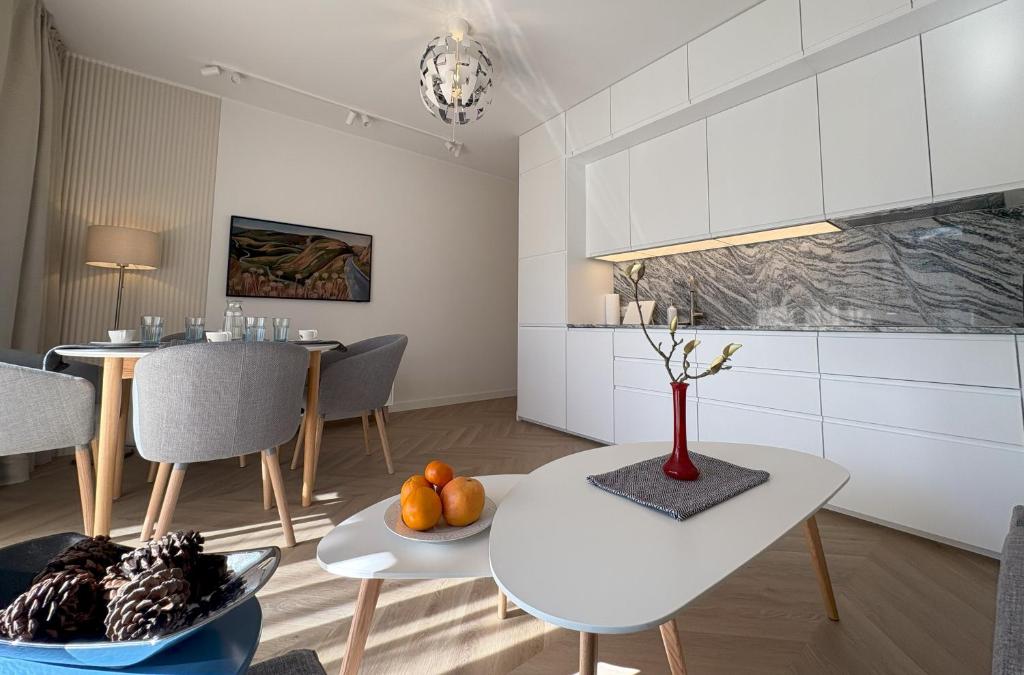 a kitchen and dining room with a table and chairs at Baltic Apartment White Diuna Supernovi in Gdynia