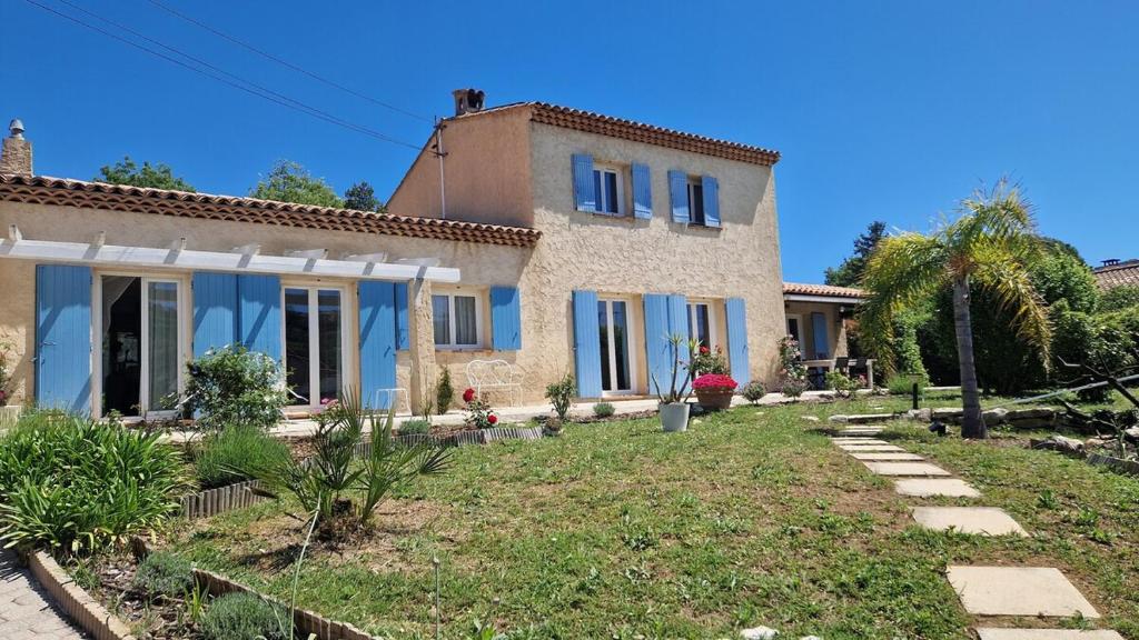 une maison avec des fenêtres bleues et une cour dans l'établissement Mas Provencal 8 pers, air-conditioned private pool, à Antibes