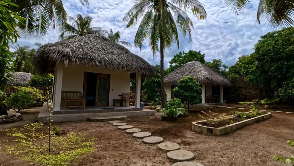 a small house with a straw roof at SA Oeona Bungalow in Nembrala