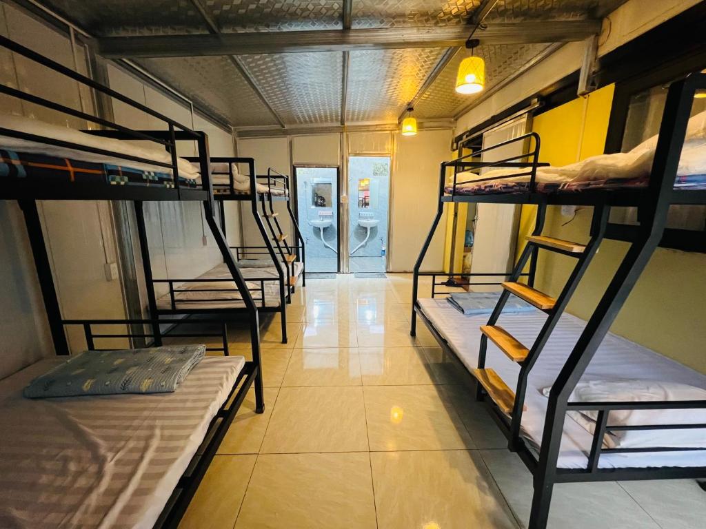 a room with several bunk beds and a hallway at Fish Farm Uncle Thanh in Xóm Soi (1)