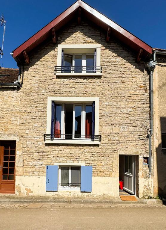 - un bâtiment en briques avec deux fenêtres et un balcon dans l'établissement La petite maison, à Noyers-sur-Serein