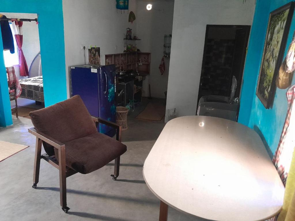 a living room with a table and a chair at Ganga river House in mayapur