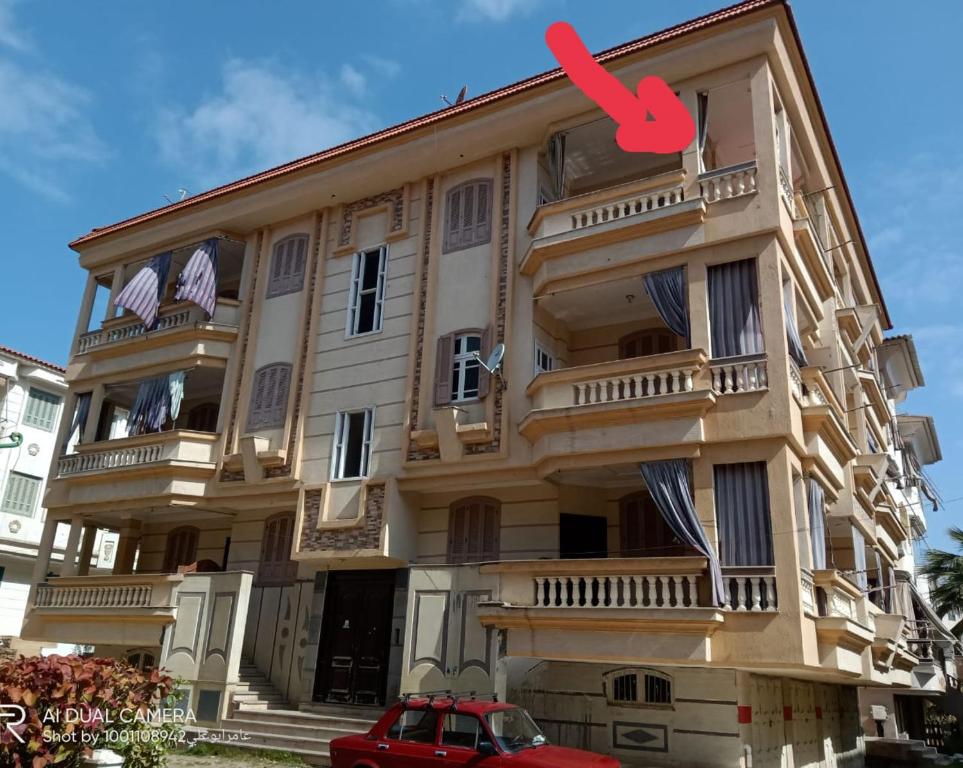 a large building with a red arrow on it at شقة مفروشة للإيجار بمصيف رأس البر سادس مطل من البحر 1 in Ras El Bar