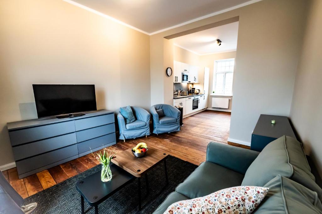 un soggiorno con un divano e una TV di 5 - mega saniertes Apartment im Dankmalschutz - nur kurze Zeit verfügbar a Brunsbüttel