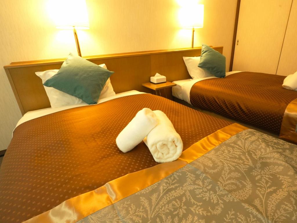 Postel nebo postele na pokoji v ubytování ロイヤルシティホテル Royalcity Hotel