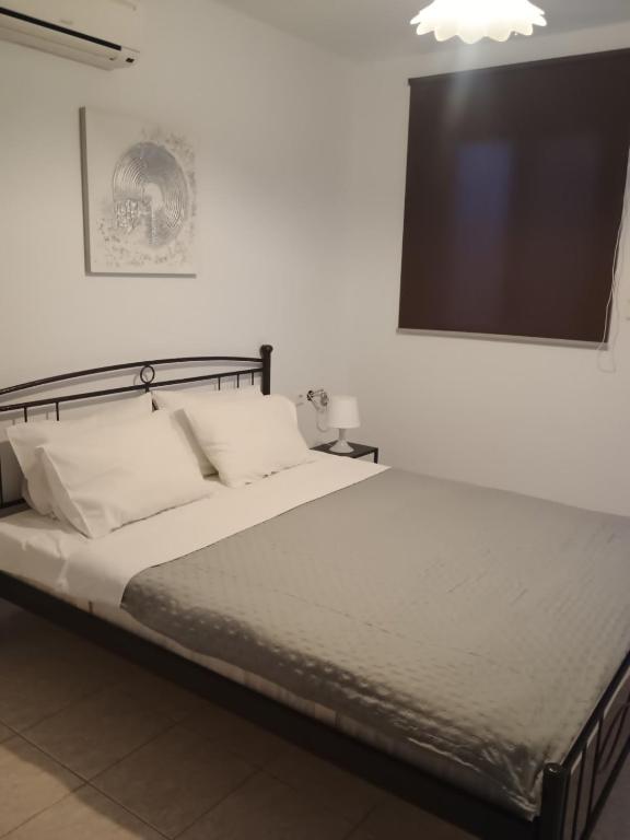 a bedroom with a bed and a flat screen tv at Nikitas apartment 2 in (( Kermetés ))