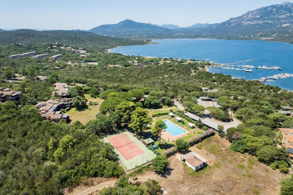 una vista aérea de una casa con una pista de tenis y un lago en Caletta Nest 38, en Porto Rotondo
