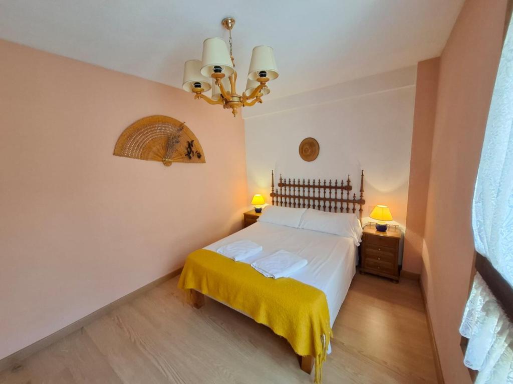 エル・プエヨ・デ・ハカにあるLa Encina, Acogedor apartamento con piscina - Arafita Apartamentosのベッドとシャンデリアのある寝室