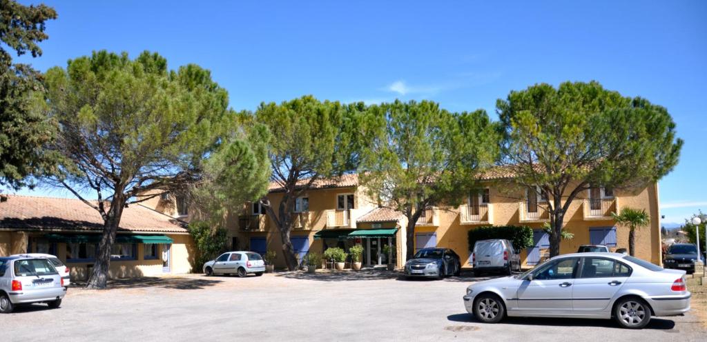 un groupe de voitures garées sur un parking devant un bâtiment dans l'établissement Le Provence, à Manosque