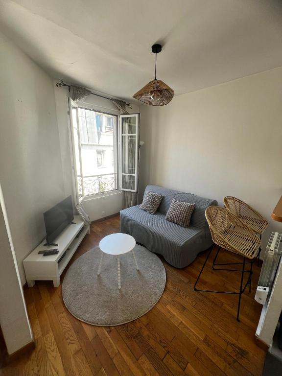 un salon avec un canapé et une table dans l'établissement Appartement Parisian Chic, à Paris