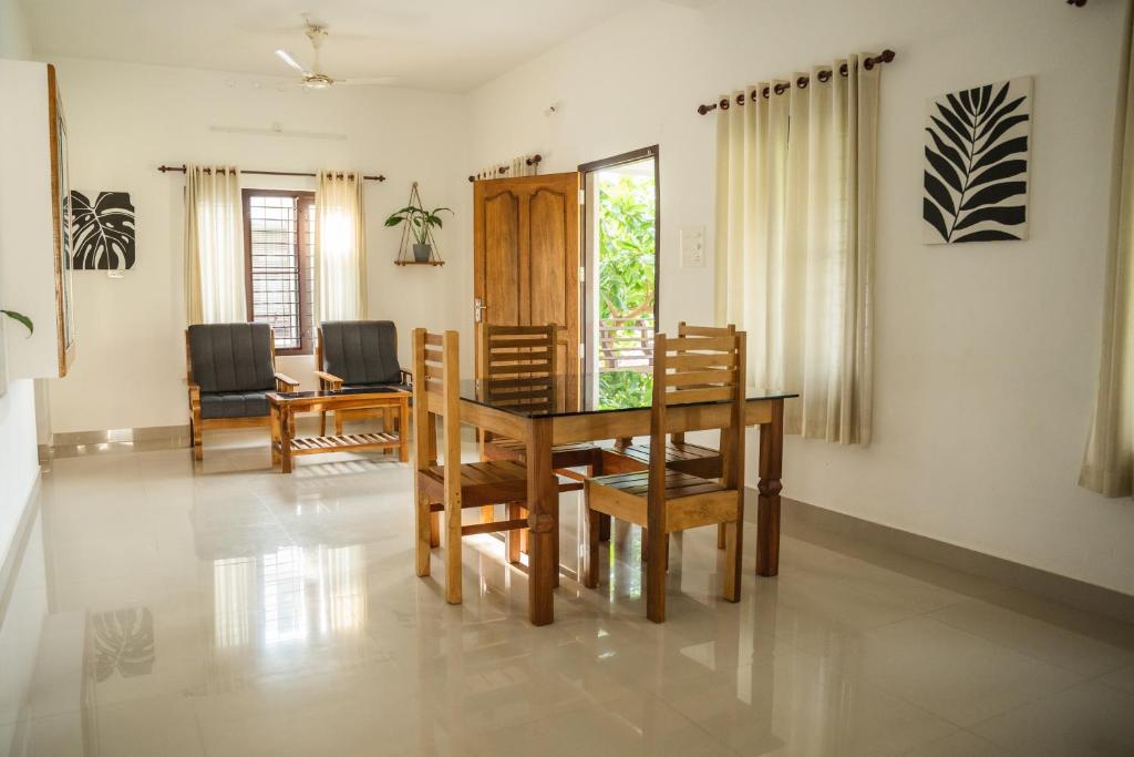 a dining room with a table and chairs at Tropical Villa in Varkala