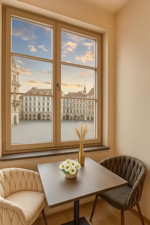 tavolo e sedie in una stanza con finestra di Aparthotel Lavilo Main Square a Graz