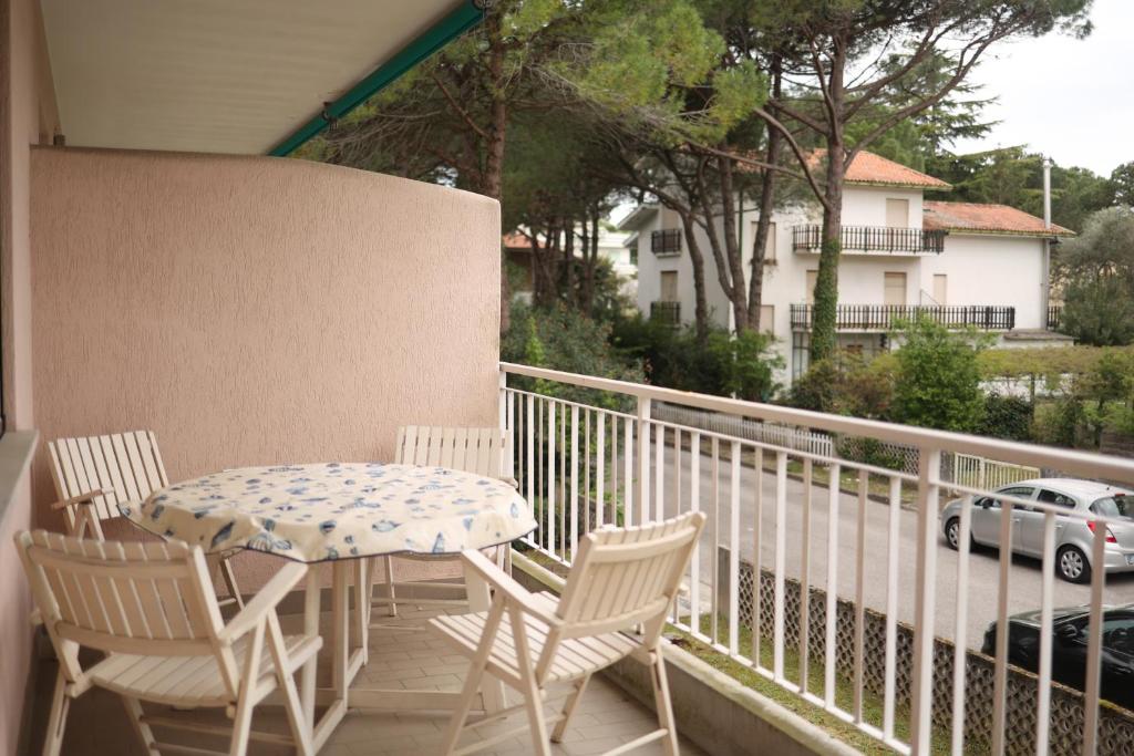 a table and chairs on a balcony with a car at Oasi blu - Charme nel cuore della pineta in Grado-Pineta