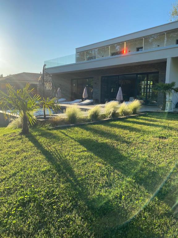 une ombre d'un bâtiment sur une pelouse dans l'établissement Villa Brisson, à Léognan