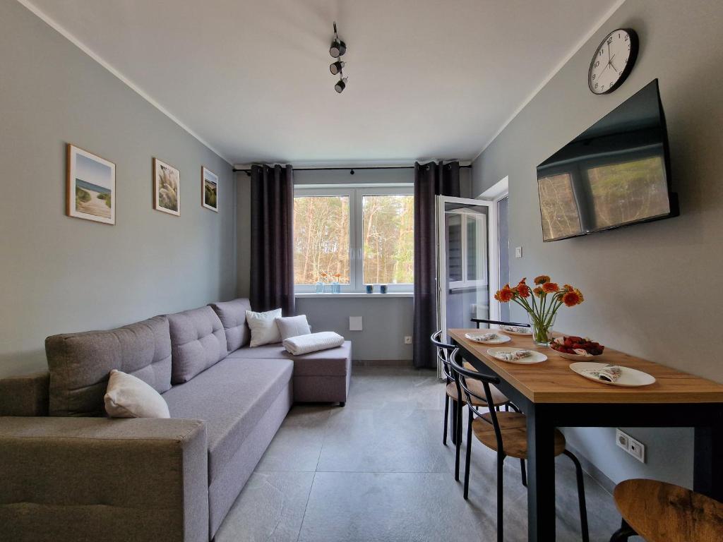 a living room with a couch and a table at Mario Leśny Klif 21 in Debina
