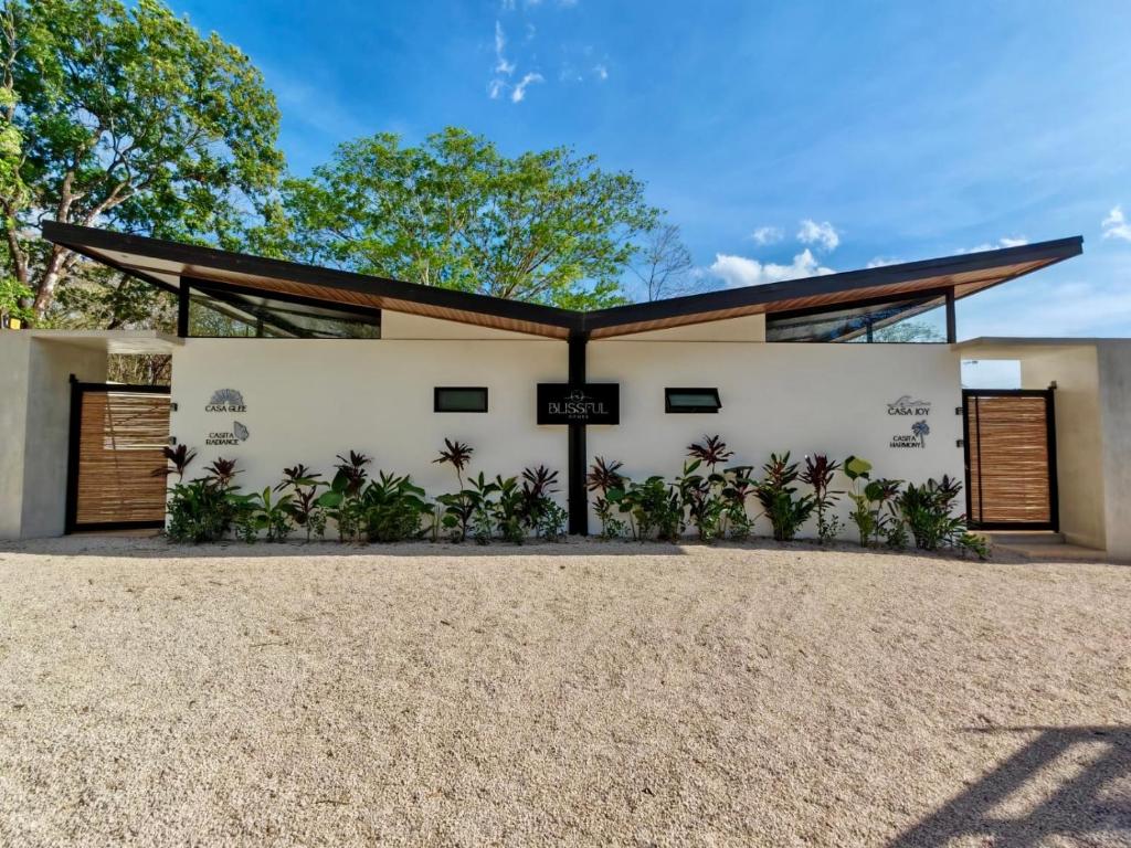 a home with a white building with a roof at Blissful Homes in Huacas