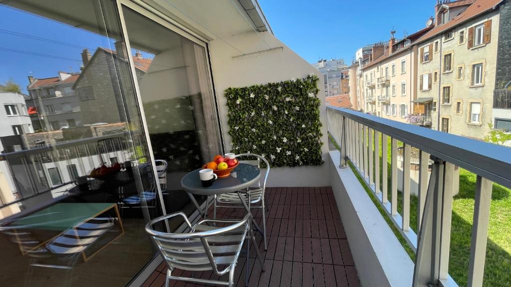 ein Balkon mit einem Tisch und Stühlen auf einem Balkon in der Unterkunft Studio plein centre, calme, parking inclus, piscine et gardien in Grenoble