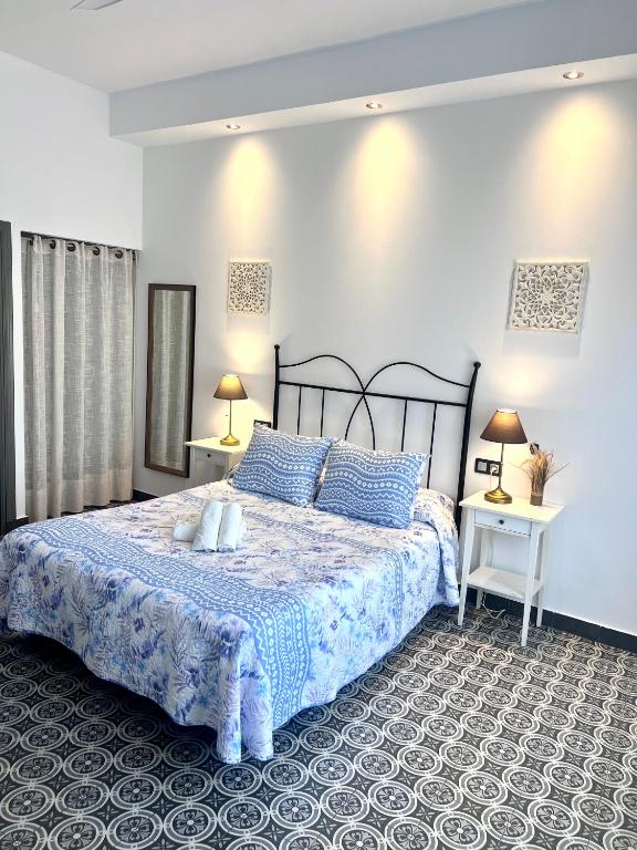 sypialnia z dużym łóżkiem z niebieskimi poduszkami w obiekcie Hostal El Faro w mieście Chipiona