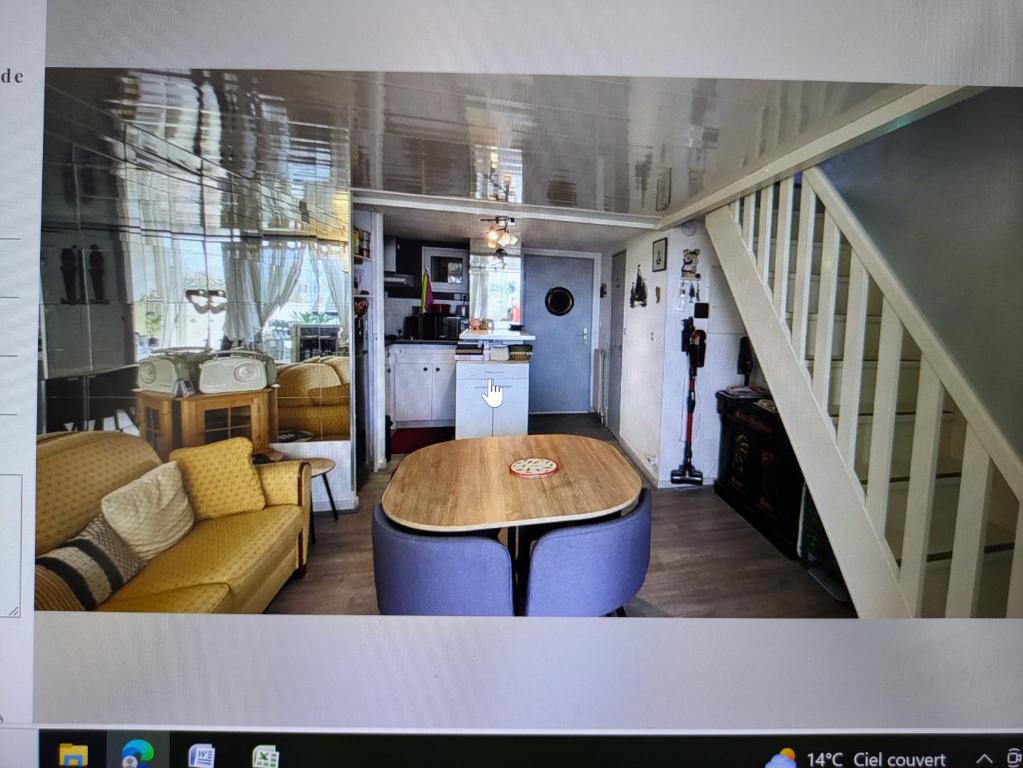 un salon avec une table et un escalier dans l'établissement Charmante maison bord de mer avec vue sur le port, au Cap d'Agde