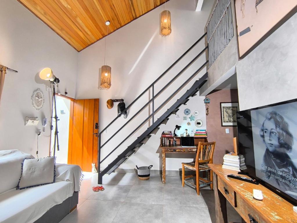 a living room with a couch and a staircase at Loft do Fotógrafo 4 - Poucos passos do Rio das Almas in Pirenópolis