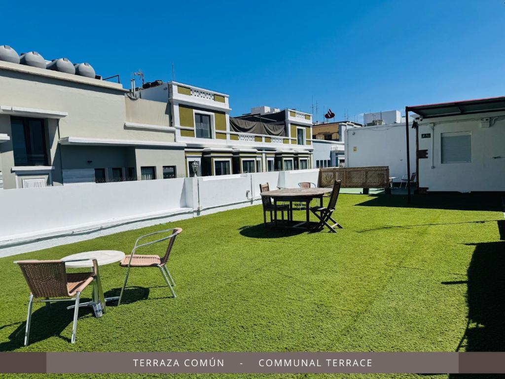 a patio with a table and chairs on the grass at Hotel Kasa in Las Palmas de Gran Canaria